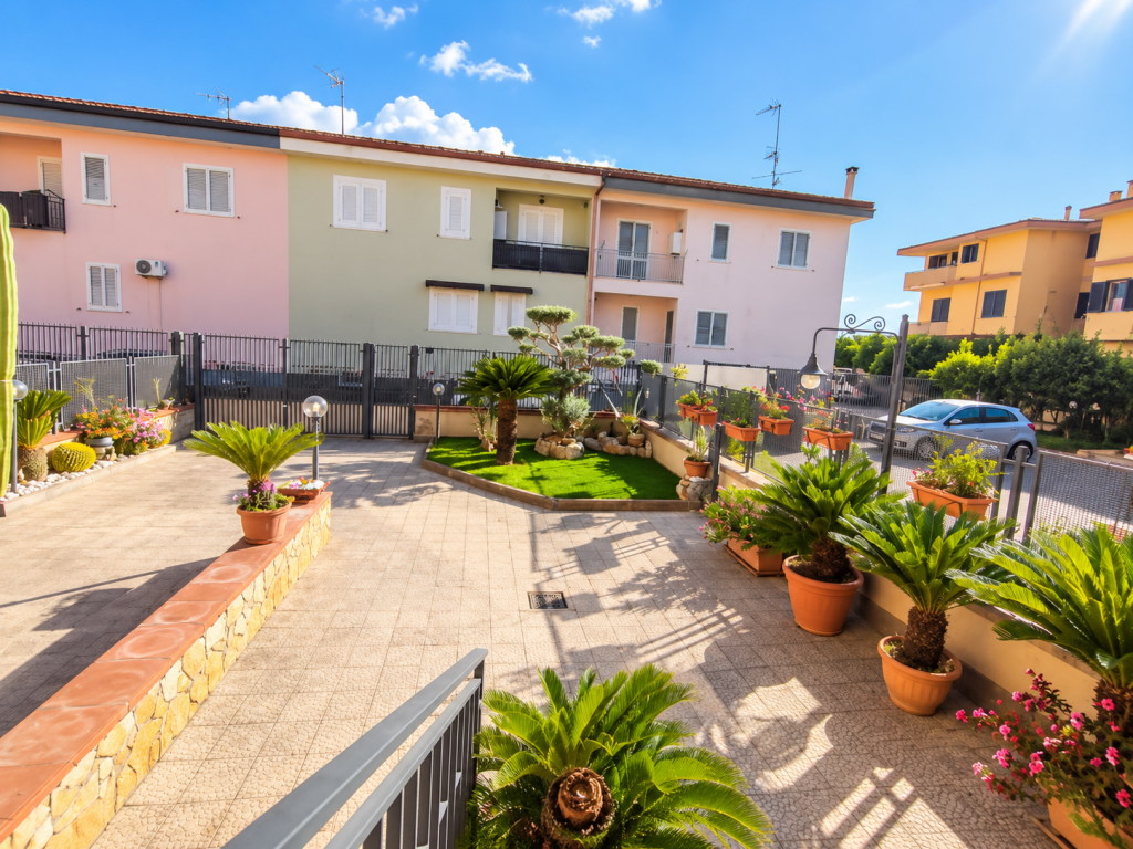 Cortile mediterraneo fiorito e soleggiato.png